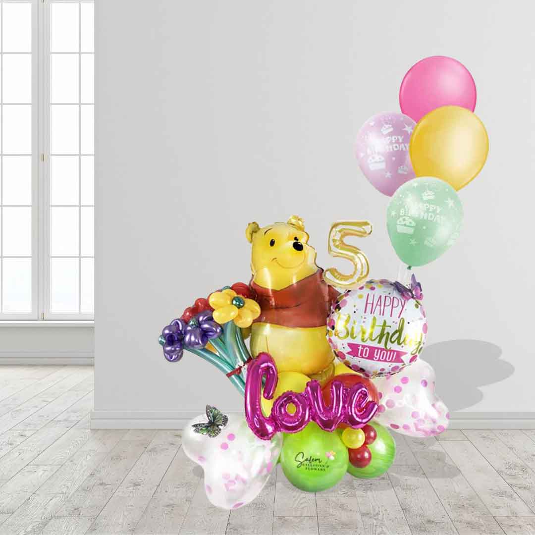 A Winnie the Pooh themed balloon marquee with helium balloons and flowers. Balloon delivery in Salem Oregon and nearby cities.