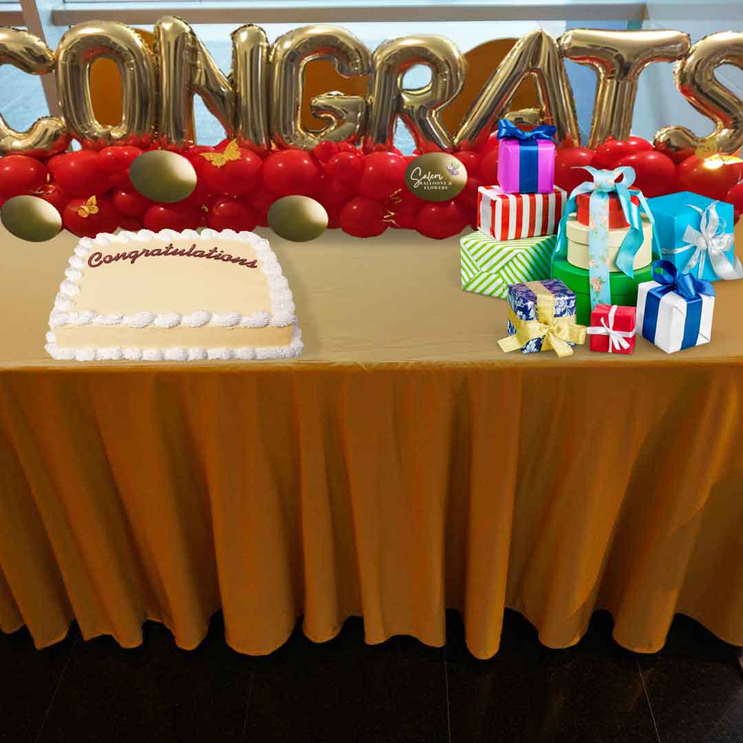 A Balloon table runner spelling CONGRATS with gold balloon letters with a balloon garland on a gift and cake table with cake and gifts. Salem Oregon Balloon decor delivery