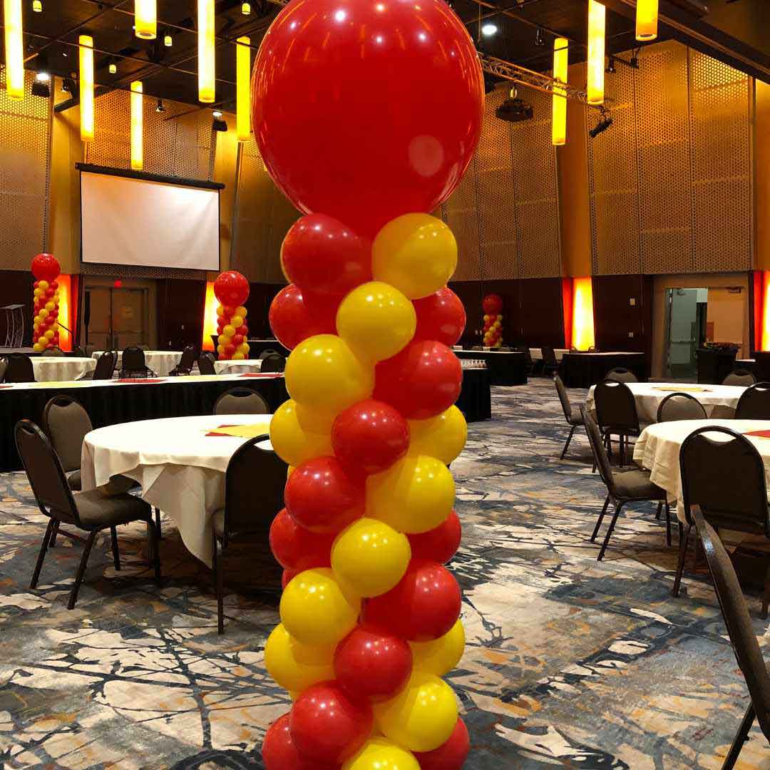 8 ft balloon columns in red and yellow standing in convention center. Salem Oregon balloon decor.