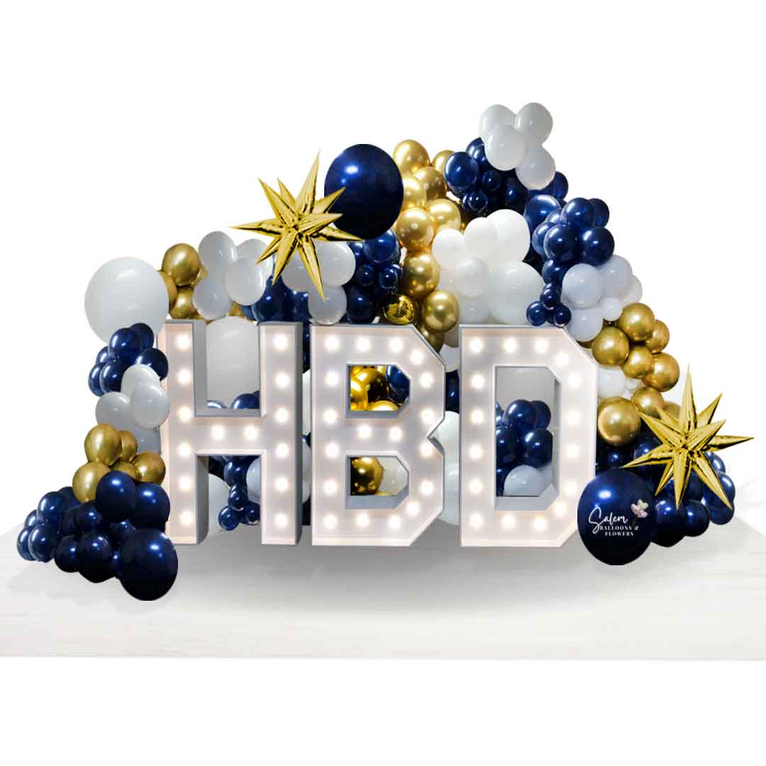 A set of Light-up HBD Marquee letters surrounded by balloon garlands in navy blue, gold and white. Salem Oregon Balloon decor.