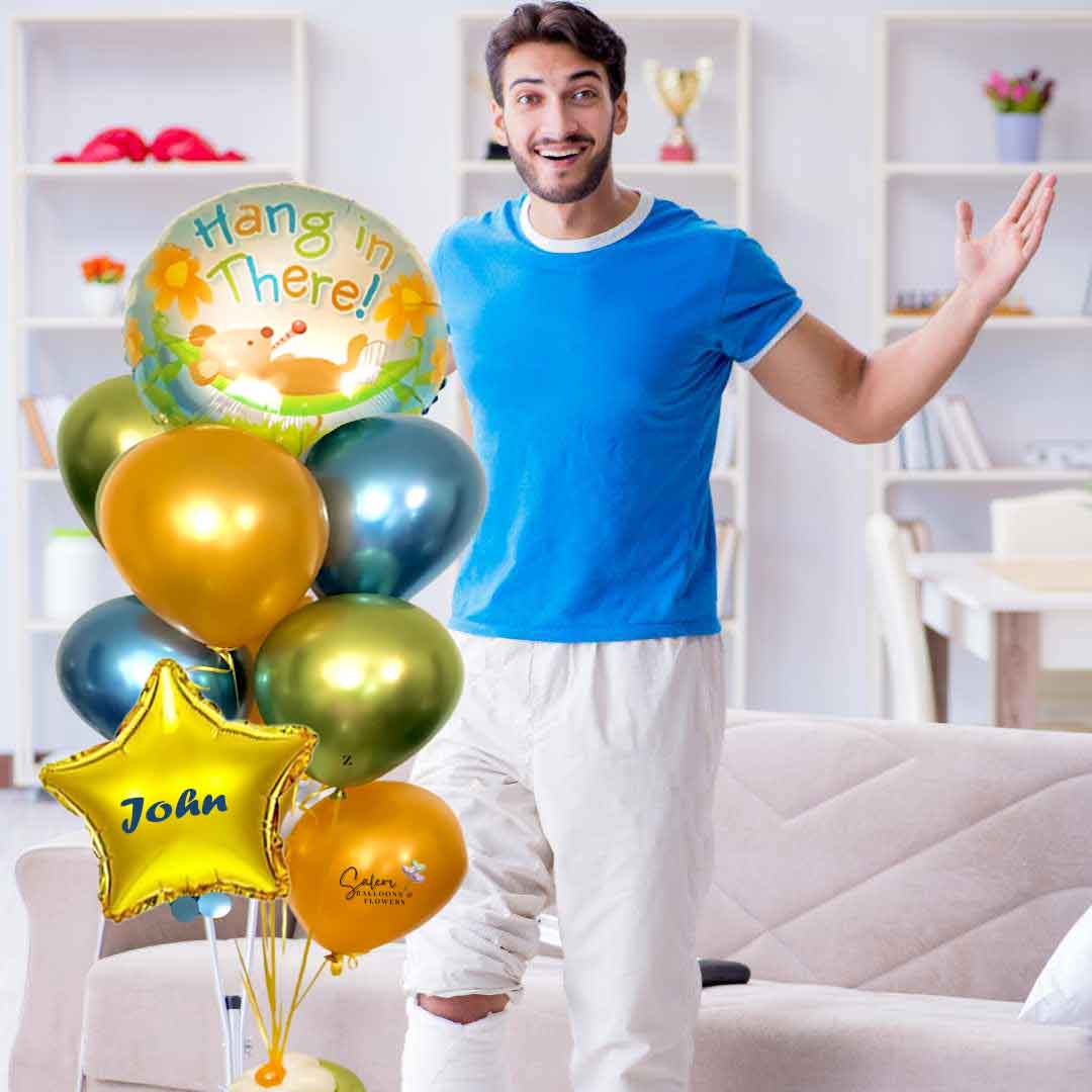 A young gay standing next to a Get well helium balloon bouquet personalized with his name. Featuring a colorful balloon with a 