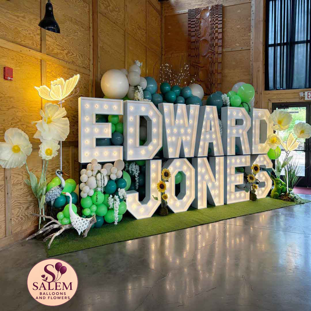 Impressive 2 story Marquee Letter display spelling Edward Jones. Decorated with balloon garlands, giant flowers and birds. Oregon Marquee Rental and Balloon Decor for events
