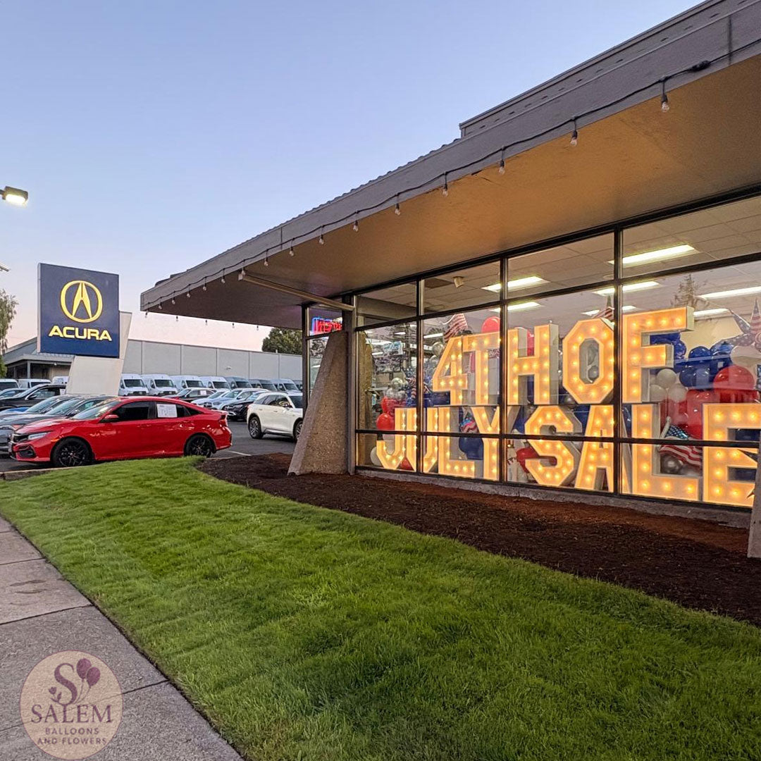 Storefront brand activation with lit marquee letters for Acura of Salem