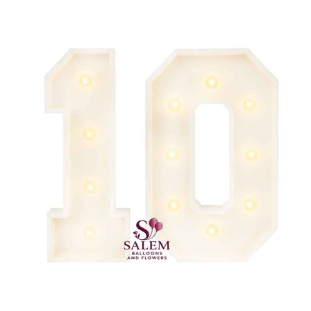 3 ft tall white wooden Marquee numbers '1' and "0' with lit bulbs on a white background. Marquee number Rentals. Oregon.