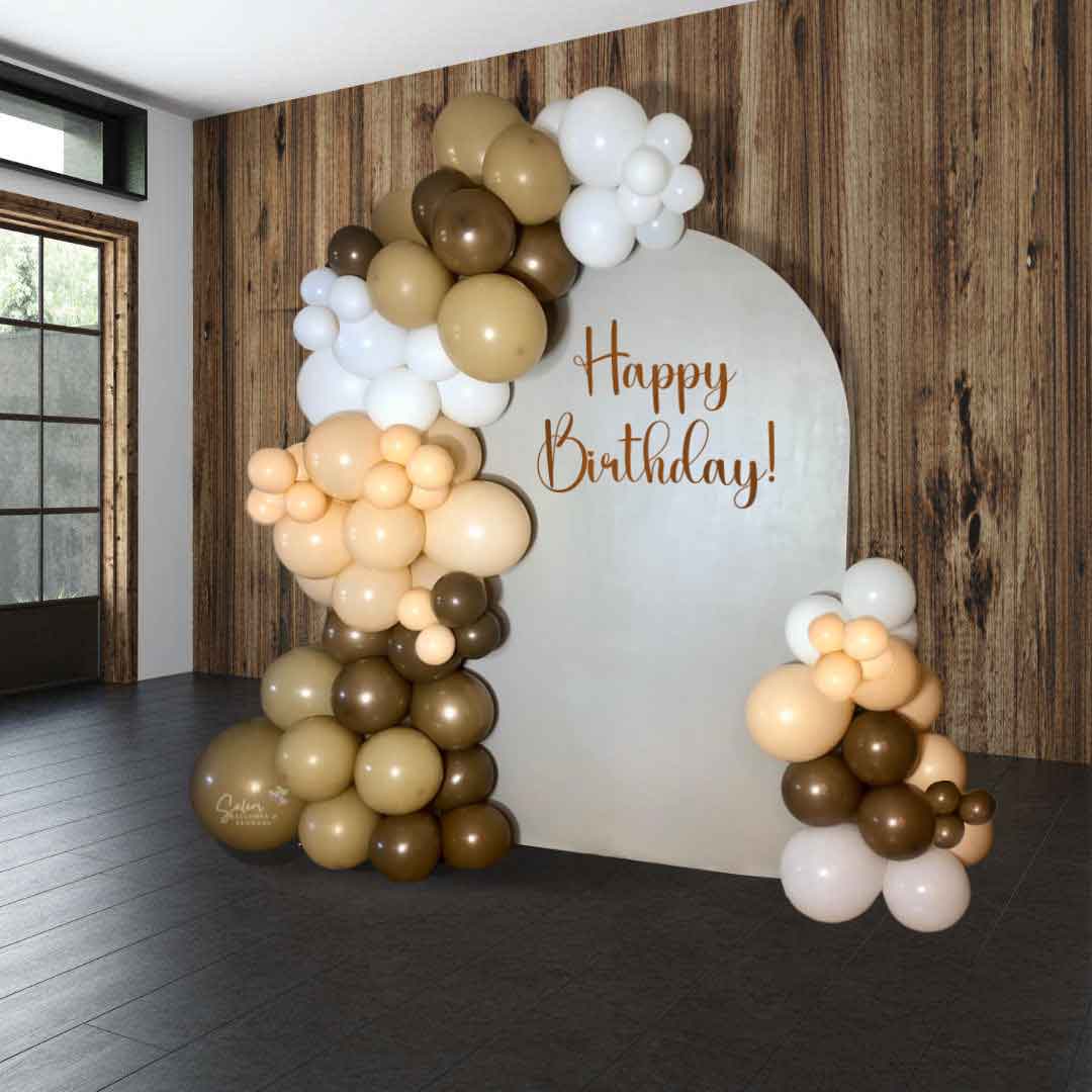 2 Organic balloon garlands in brown, beige, blush and white decorating a single arch panel with a Happy Birthday sign for Balloon decor. Oregon Balloon Decor.
