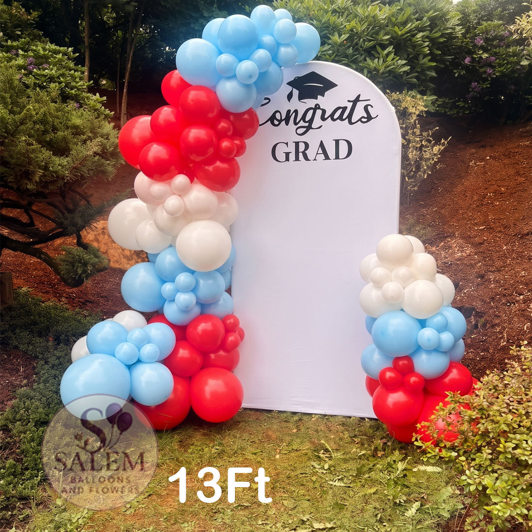 13ft double sided balloon garland attached to an arch backdrop in blue, red and white. Balloon decor in Oregon.