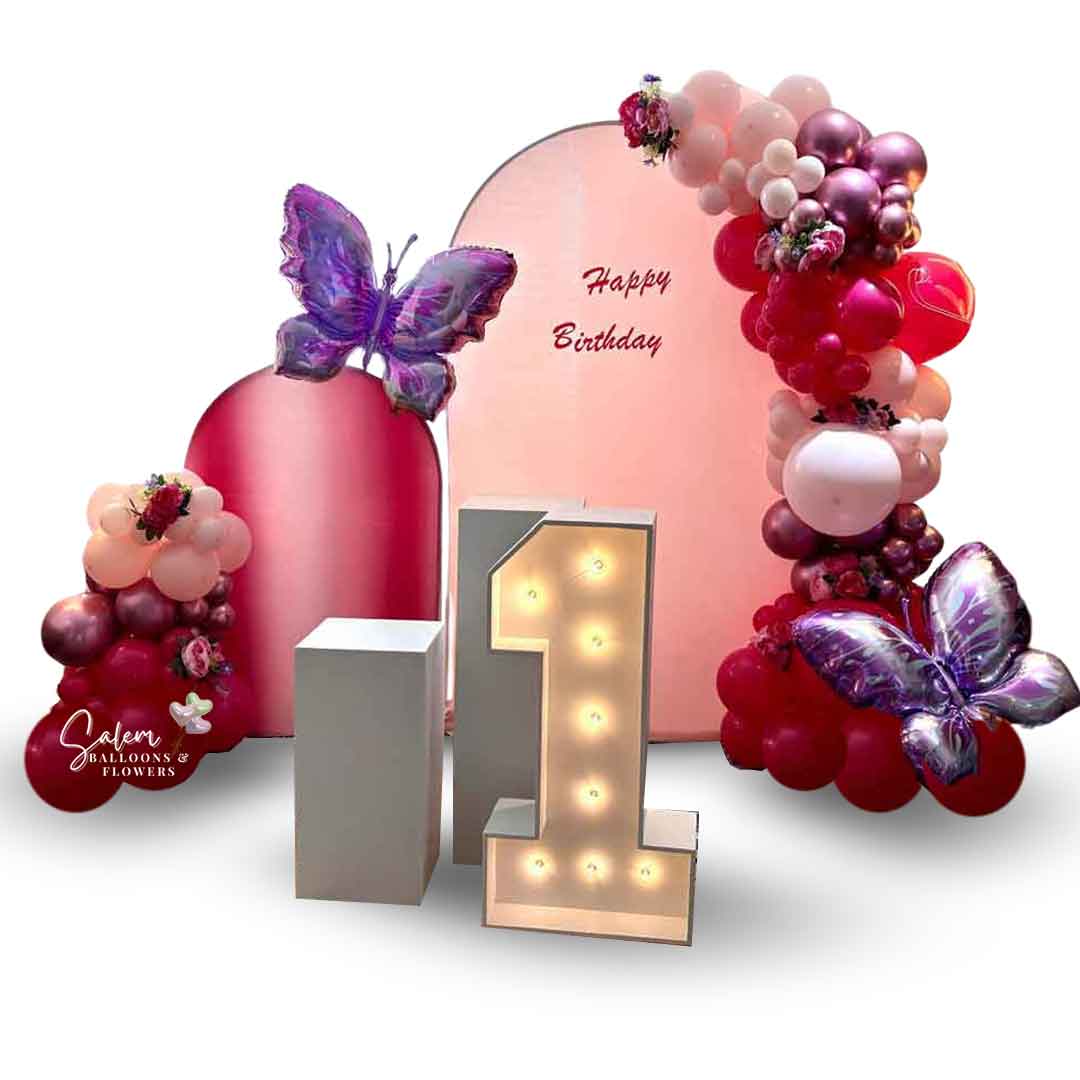 Butterfly-themed Balloon Decoration. 2 Panels, 2 garlands, 2 cake stands and one 1 light up Marquee Number. In a pink color palette. Balloon Decor. Oregon.