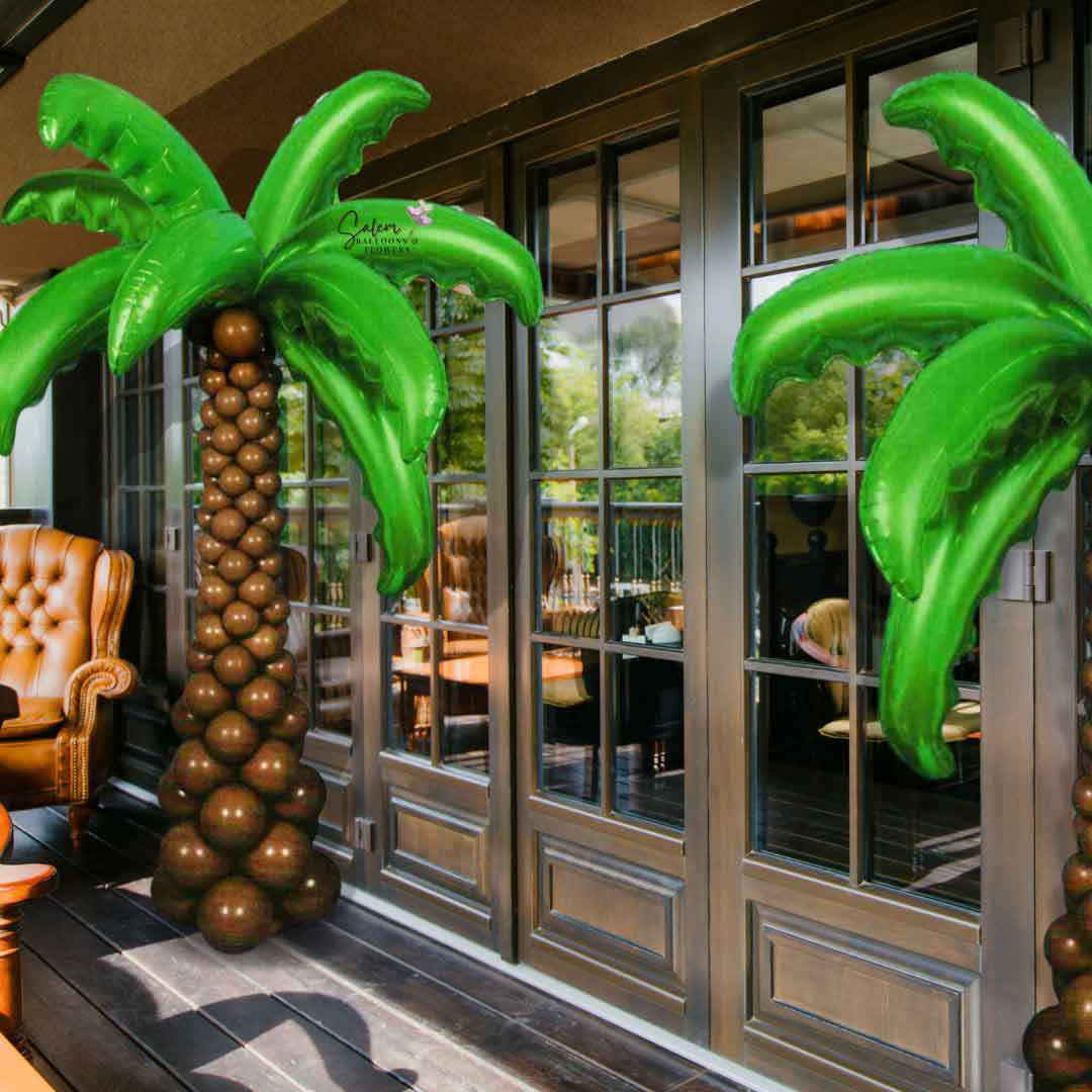 2 Palm trees standing in front of a restaurant entrance. The trunk made of latex balloons  while the palm leaves are Mylar balloons shaped as palm tree leaves. Balloon decor Salem Oregon and nearby cities.