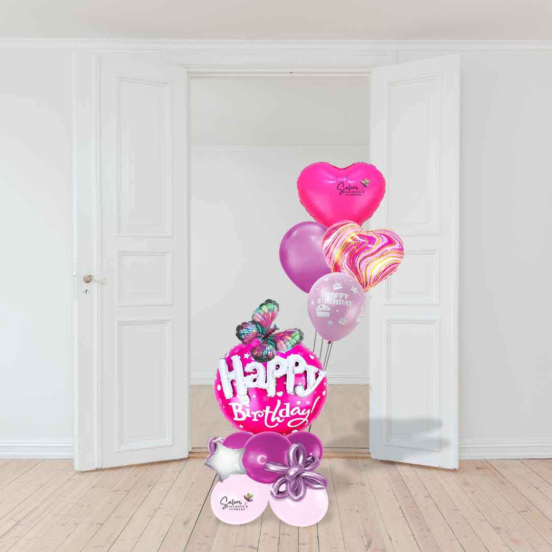 A blast of pink birthday balloon bouquet in barbie pink colors standing in front of a door. Balloons Salem Oregon and nearby cities.