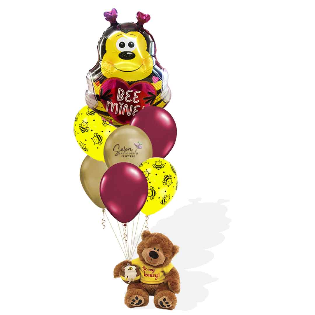 Valentine's balloon bouquet with teddy bear holding a bee mylar balloon and a set of latex helium balloons. His T-shirt has a 