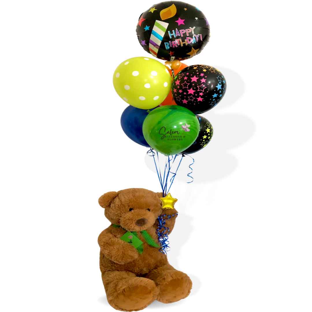 Large teddy bear holding a set of helium-filled balloons with a 