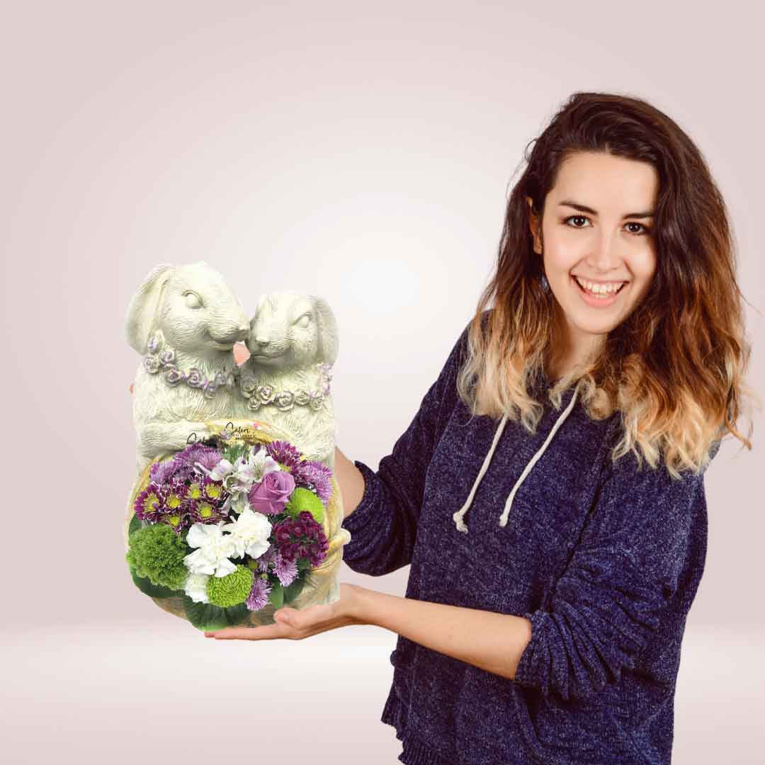 Woman holding a Spring flower arrangement in a bunny vase. Fresh flowers in a white bunnies vase. Flower delivery in Salem OR and nearby cities.