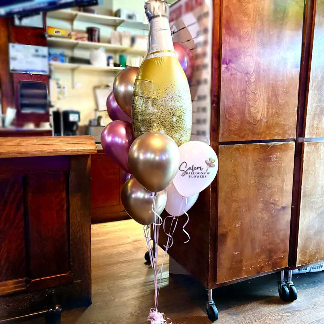 Helium Balloon Bouquet featuring a large champagne balloon bottle in gold and pink. Balloon delivery. Salem Oregon and nearby cities