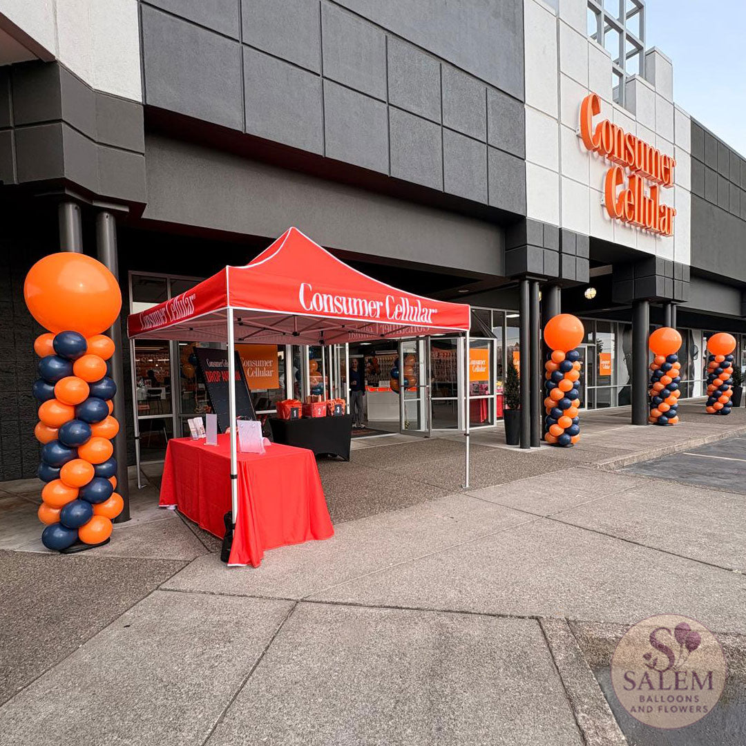 8 ft tall Round top balloon columns in navy blue and orange for the grand opening of the  Consumer Cellular 100 store in Salem Oregon by Salem Balloons and Flowers. Storefront Visibility. 