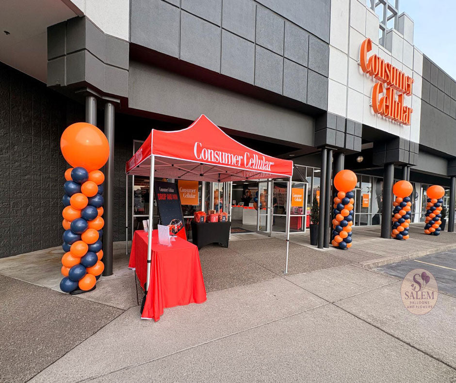 8 ft tall Round top balloon columns in navy blue and orange for the grand opening of the  Consumer Cellular 100 store in Salem Oregon by Salem Balloons and Flowers. Storefront Visibility. 