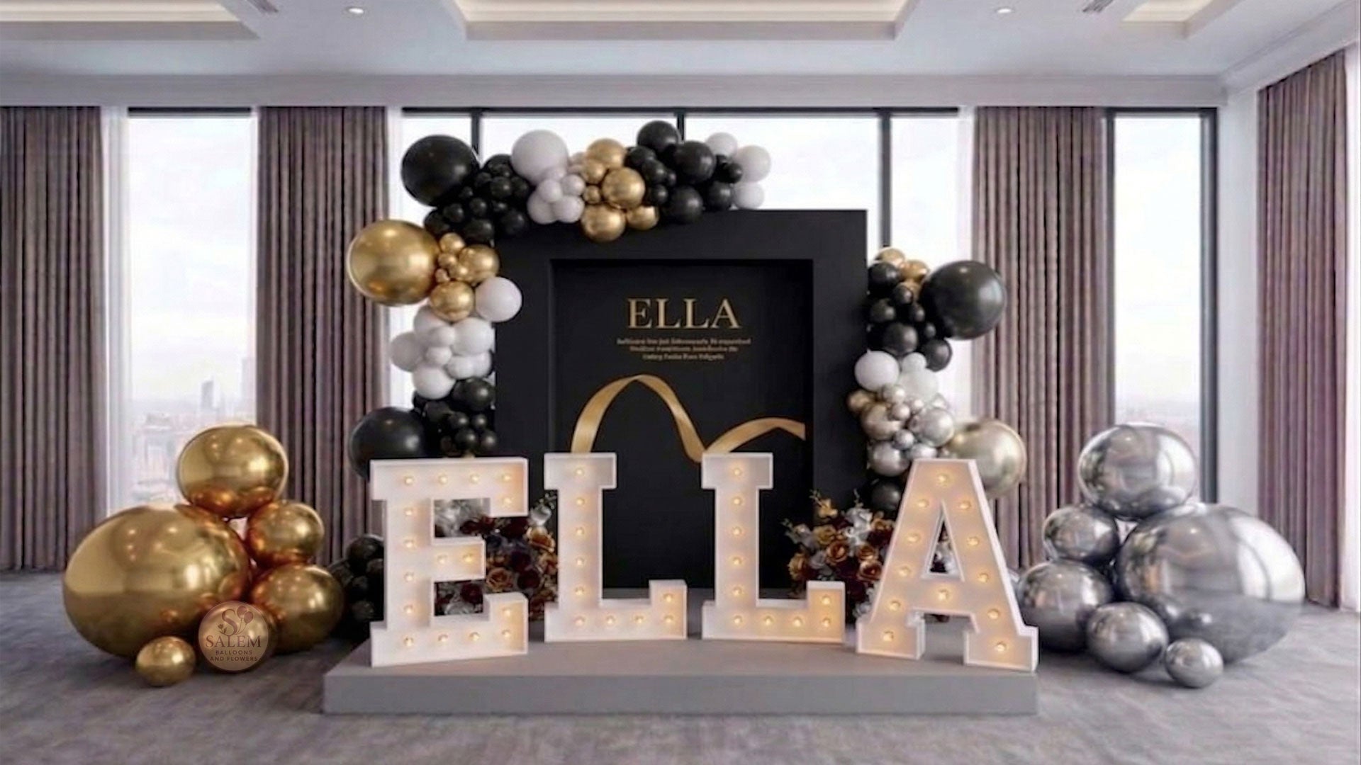 Decorative executive setup for a brand display with 'ELLA' letter lights and balloon garlands, on a platform in a venue room with large windows. Event decor. Oregon.