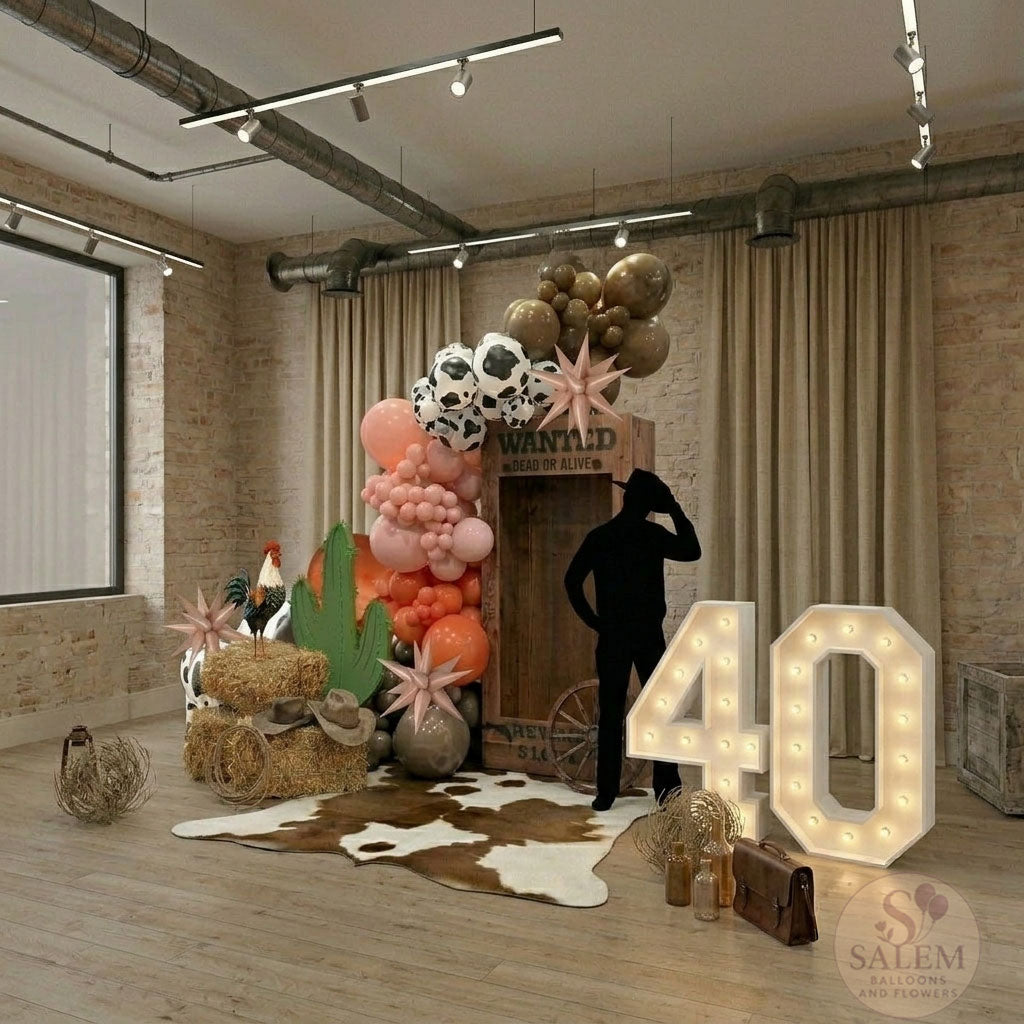 Cowboy themed decorative setup with balloon garlands, props, and a cowboy silhouette  in a room with brick walls and wooden floor. Oregon.