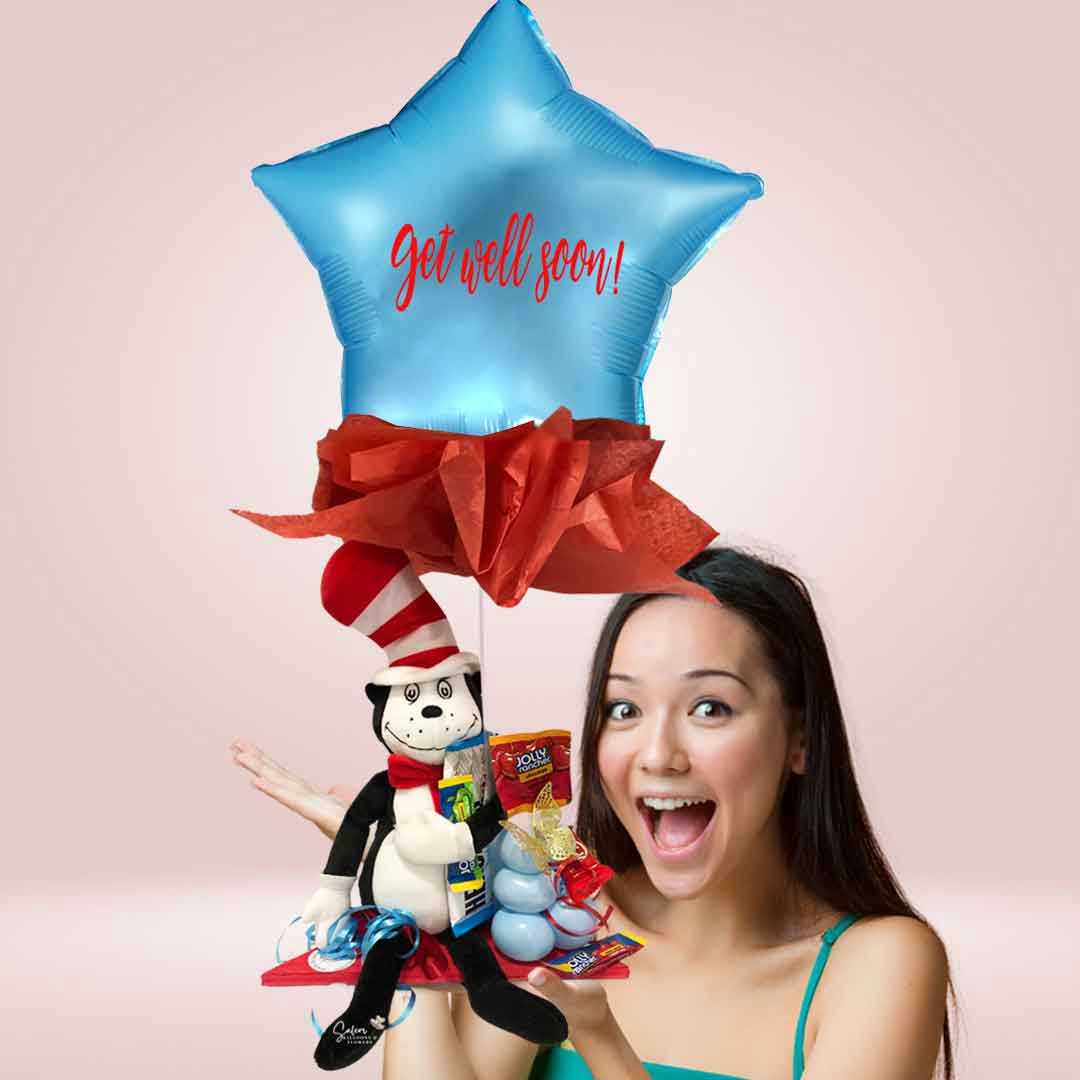 A girl holding a Get well balloon bouquet with Dr. Seuss plush sitting on a wooden base, with candy and a star balloon with a "Get Well Soon" message. Salem Oregon balloon delivery.