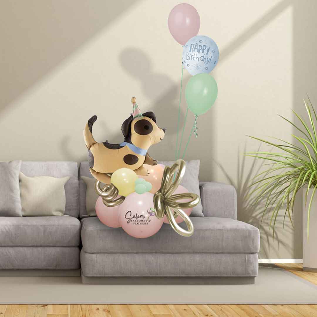 Birthday Balloon Bouquet in pastel colors, featuring a beige dog balloon with brown spots  and decorated with curly balloons standing on a sofa. Oregon Balloon delivery.