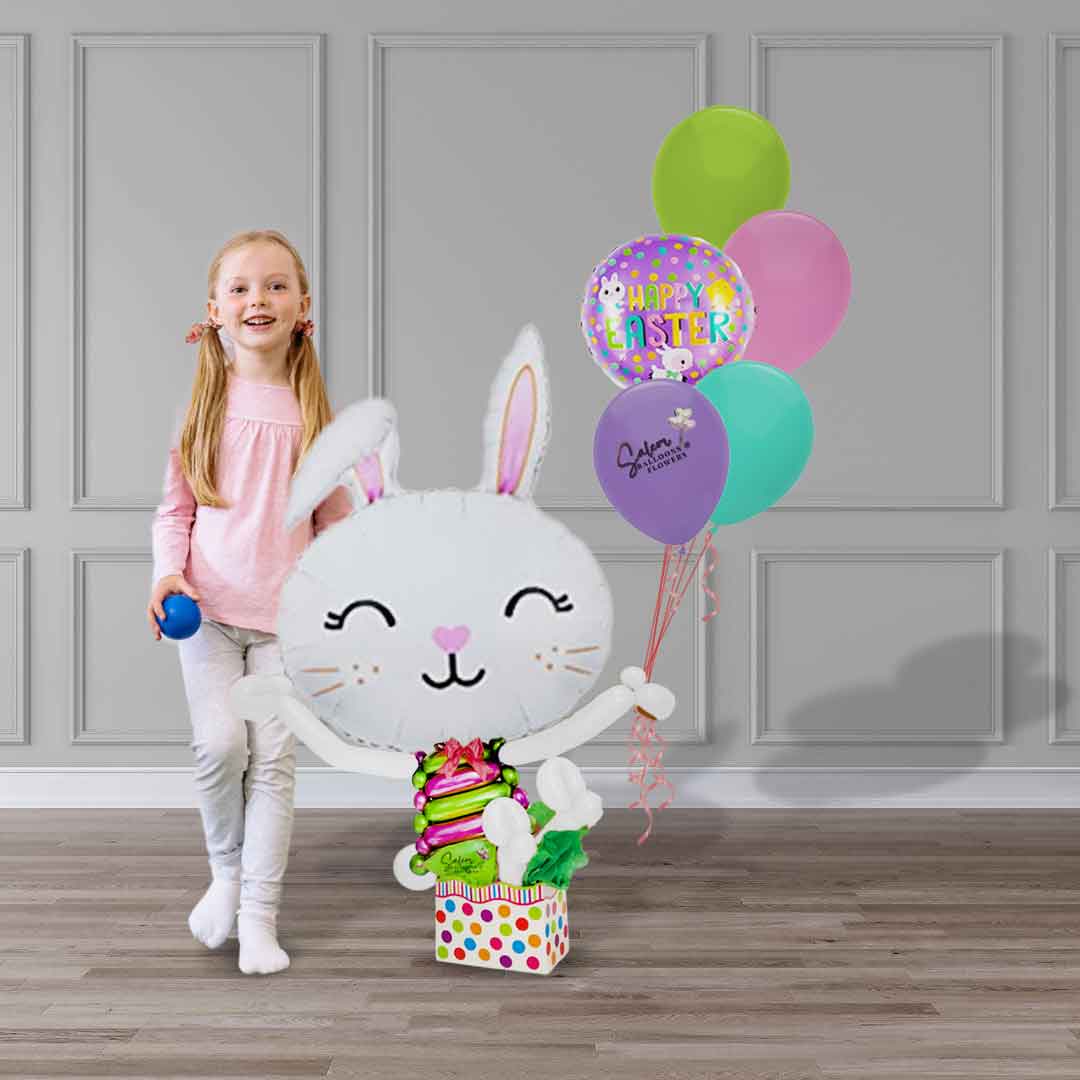 A little girl standing next to a big easter bunny balloon bouquet with helium balloons. Delivery in Salem Oregon and nearby cities.
