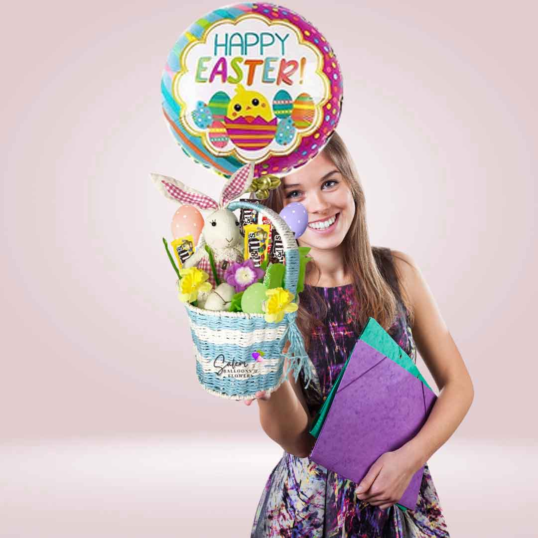 A girl holding a A gorgeous Easter blue basket filled with a delicious assortment of  Candy and Chocolates. Featuring an adorable bunny and an Easter themed Mylar balloon. Delivery available in Salem OR and nearby cities.