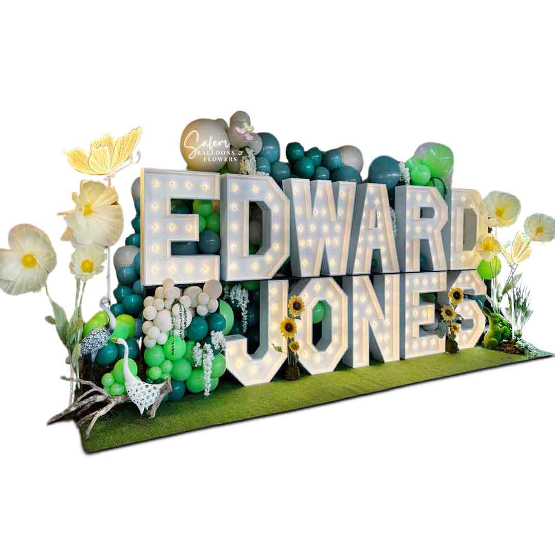 18 ft long x 9 Ft tall 2-story Light up marquee Letter Display with Balloon Decor, giant flowers and birds and lit butterflies. Spelling Edward Jones. Marquee Letter rental and Balloon decor service. Oregon.