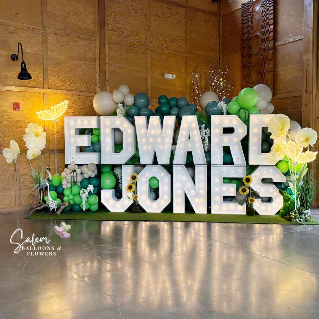18 ft long x 9 Ft tall 2-story Light up marquee Letter Display with Balloon Decor, giant flowers and birds and lit butterflies. Spelling Edward Jones. Marquee Letter rental and Balloon decor service. Oregon.
