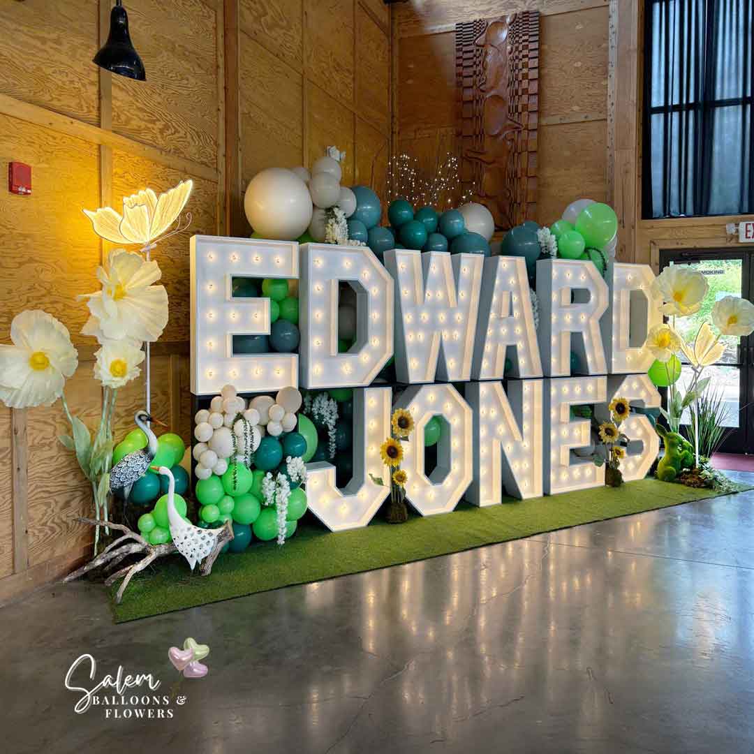 18 ft long x 9 Ft tall 2-story Light up marquee Letter Display with Balloon Decor, giant flowers and birds and lit butterflies. Spelling Edward Jones. Marquee Letter rental and Balloon decor service. Oregon.