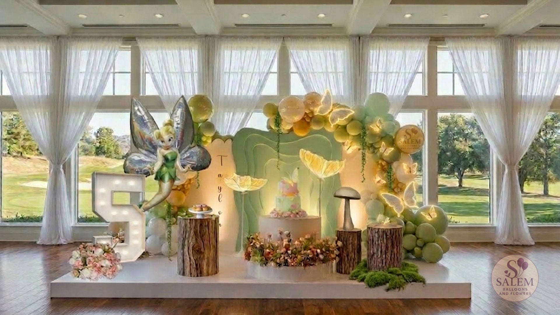 Fairy themed balloon decoration with 3 panels and balloon decor with lit butterflies, decorated with flowers and balloon garlands, lit Marquee number 5 in a room with large windows. Luxury balloon decor. Oregon.