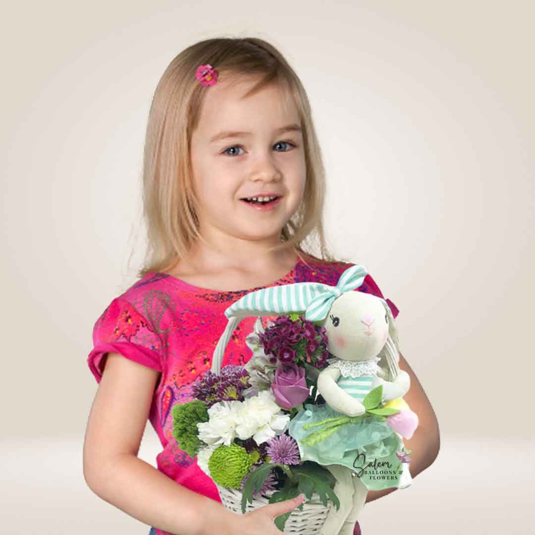 Girl holding a flower basket with a bunny doll in a mint dress. Salem Oregon Flower delivery.