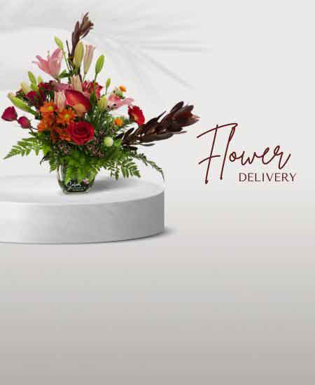 Flower arrangement in a square glass vase with roses and lilies. Flower delivery Salem Oregon and nearby cities.