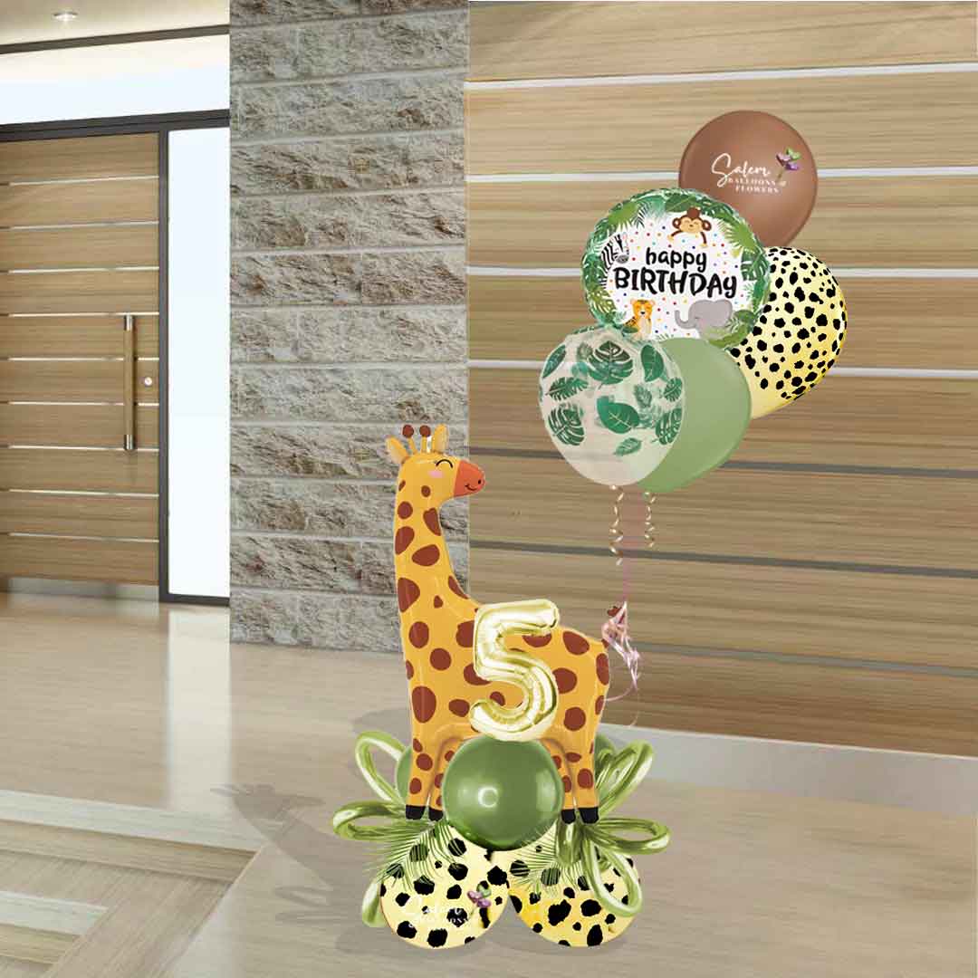 Safari themed balloon bouquet featuring a larg Giraf balloon standing on a balloon base with palm leaves and balloon bows and a set of helium balloons. Balloons Salem Oregon