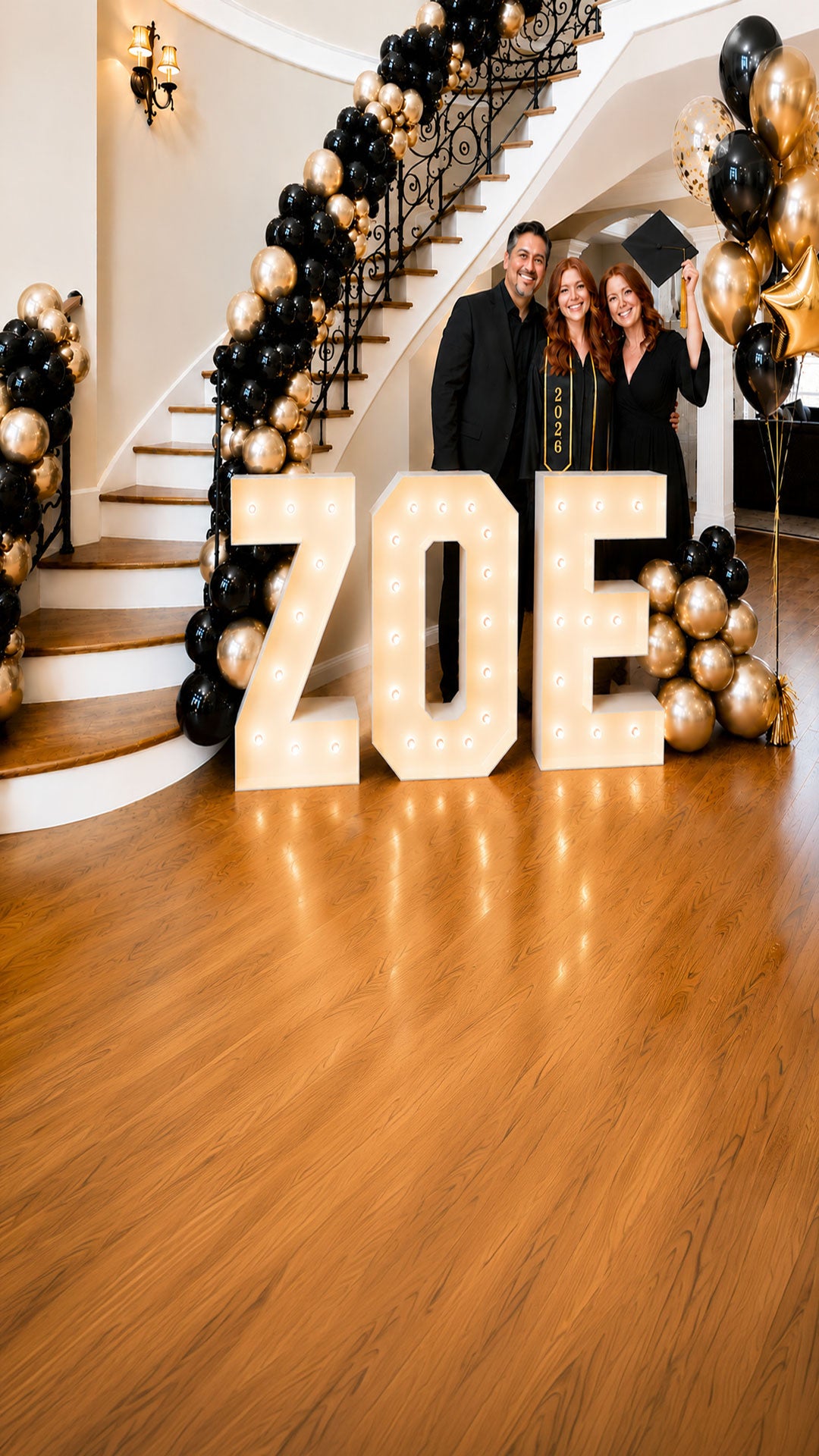 Luxury graduation party decorations in Salem Oregon featuring illuminated marquee letters, black and gold balloon garland staircase installation, and custom balloon decor by Salem Balloons and Flowers.