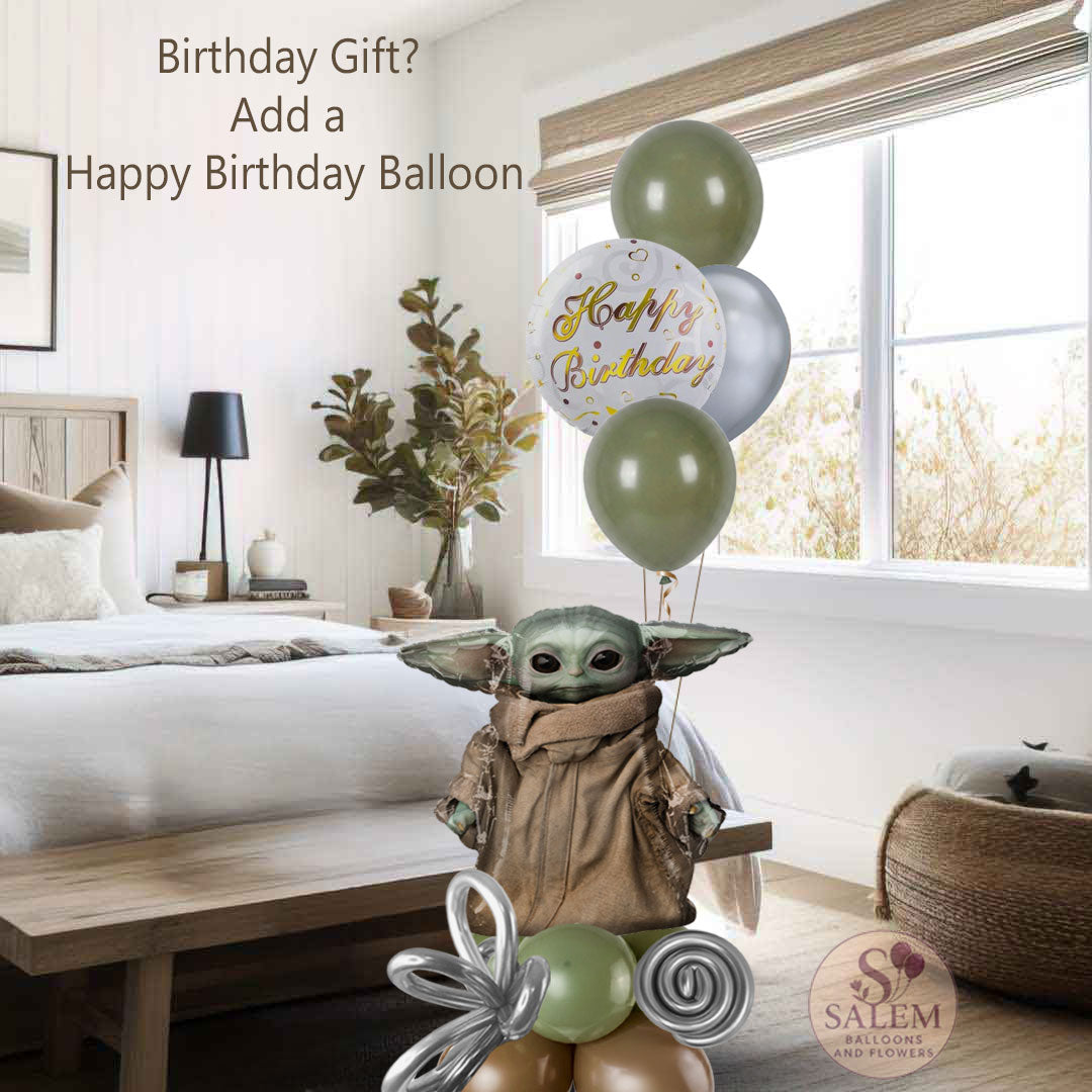 Grogu-inspired balloon bouquet with sage green, silver, and neutral balloons styled in a modern luxury arrangement sitting on the floor at the center of white and neutral colors bedroom. a  by Salem Balloons and Flowers.