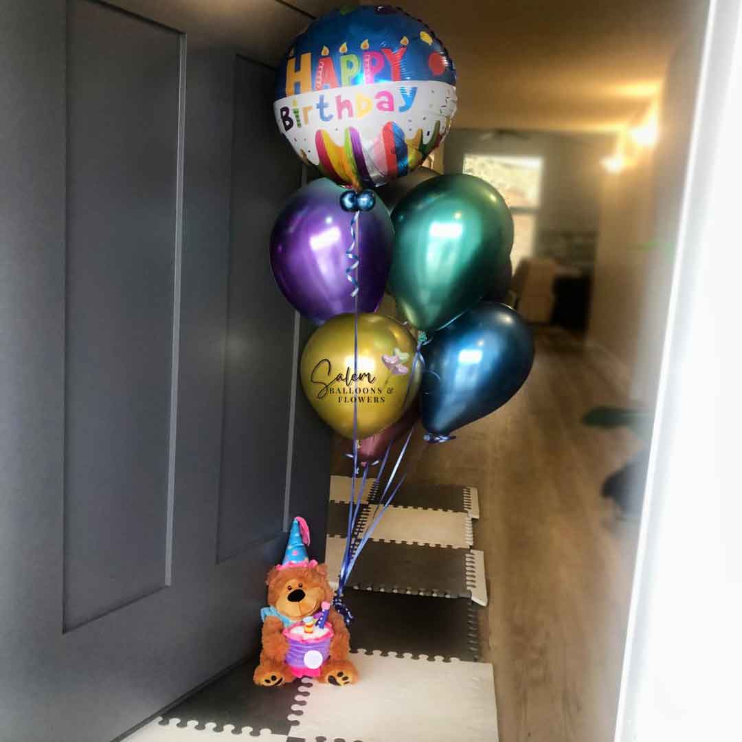 Birthday Helium Balloon Bouquet. Featuring a Colorful Mylar Balloon with candles and a Happy Birthday" message and a set of Latex Chrome Helium Balloons. Topped up with a Musical Teddy Bear holding a cake. Oregon Balloon Delivery.