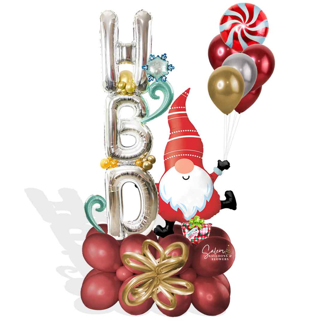HBD. Christmas Balloon bouquet features a large Gnome balloon holding HBD balloon letters in one hand and a set of helium balloons. Balloons Salem Oregon and nearby cities.