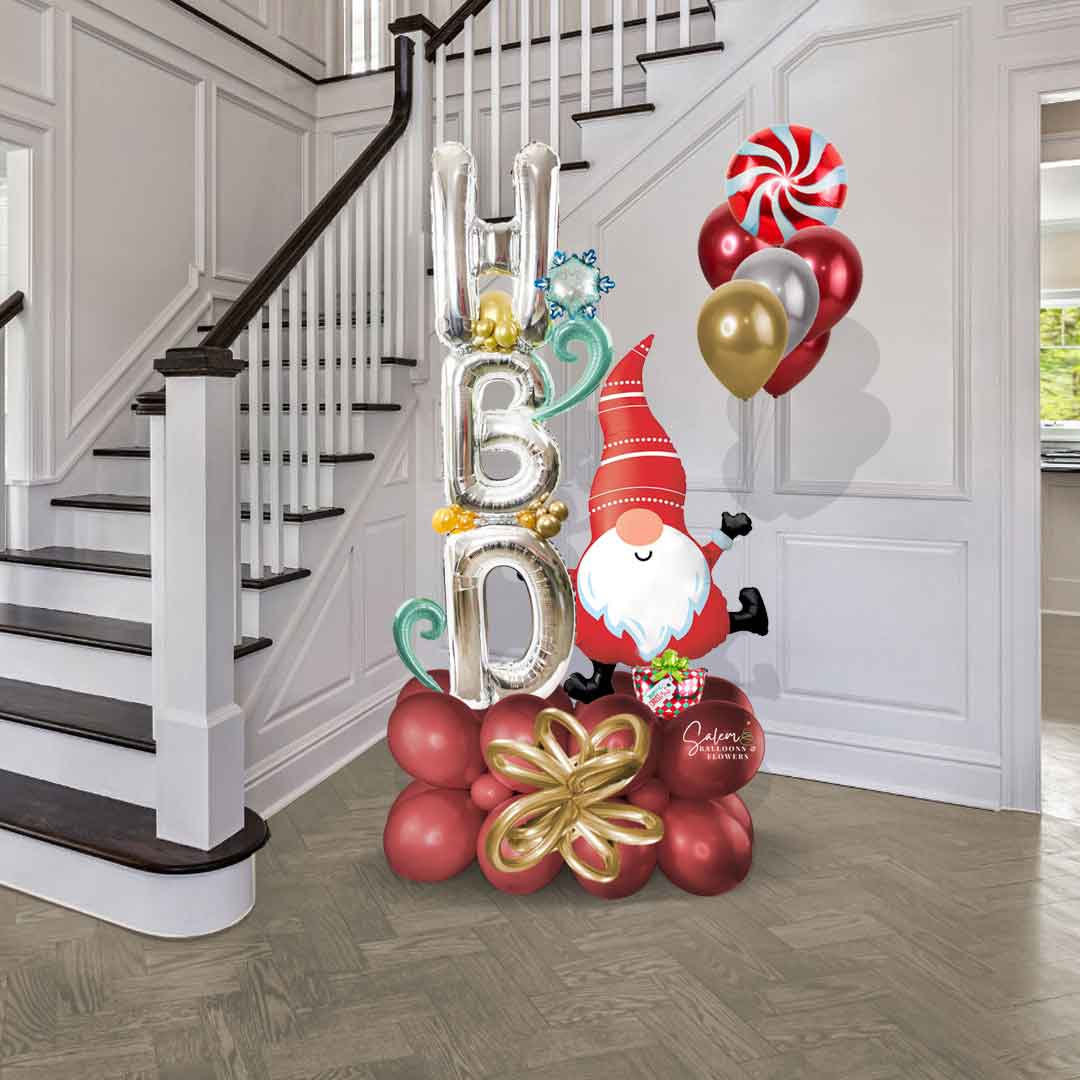 HBD. Christmas Balloon bouquet features a large Gnome balloon holding HBD balloon letters in one hand and a set of helium balloons Size chart