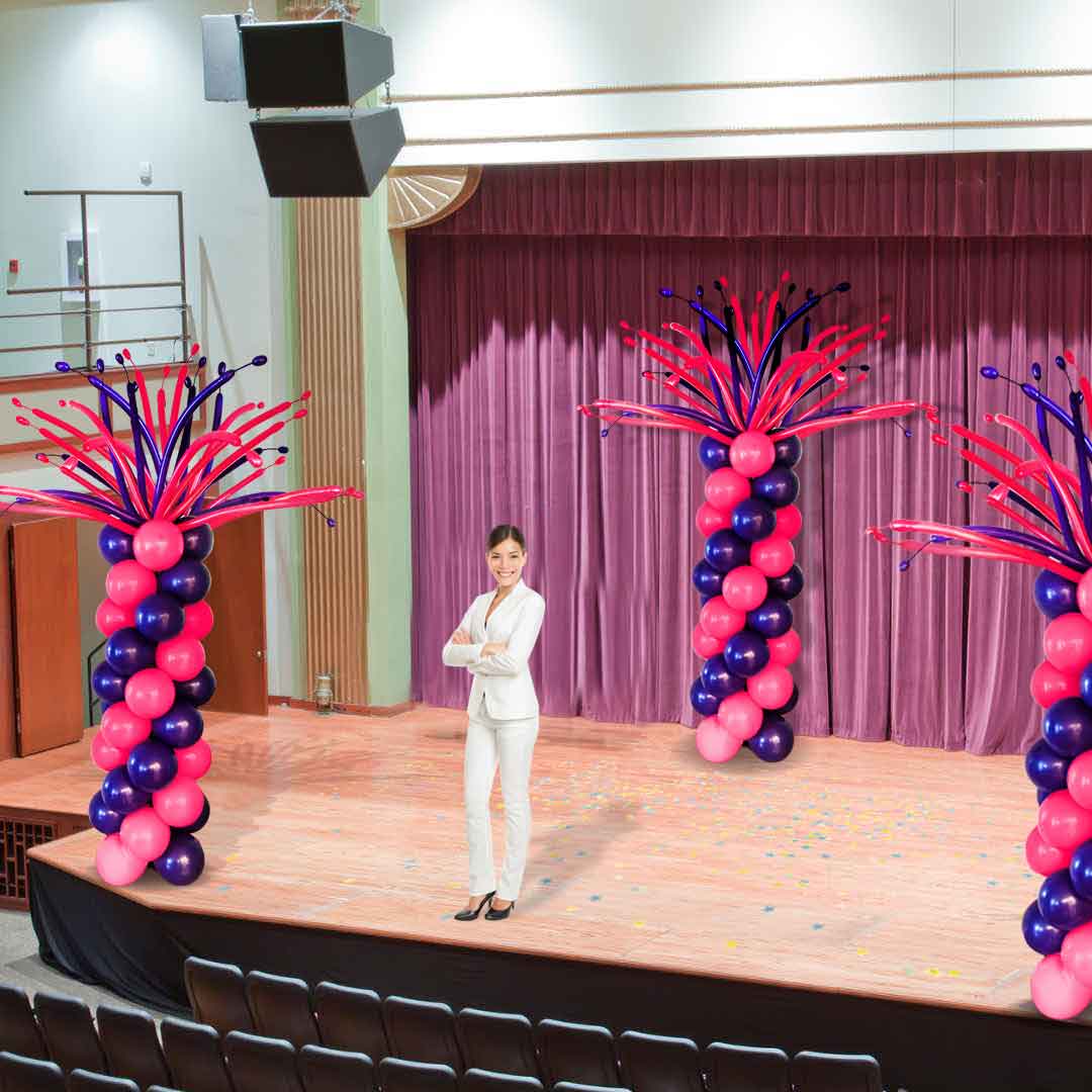 Stage decorated with 3 Hairy balloon column, featuring a crazy balloon topper made out of swister balloons in pink and purple. Delivery available in Salem-Keizer Oregon and nearby cities.