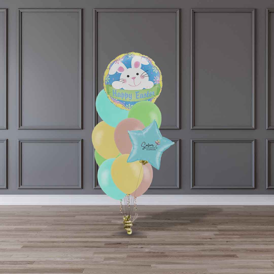 A Helium-filled Happy Easter balloon bouquet in pastel colors standing in front of a gray wall. Balloon delivery Salem Oregon