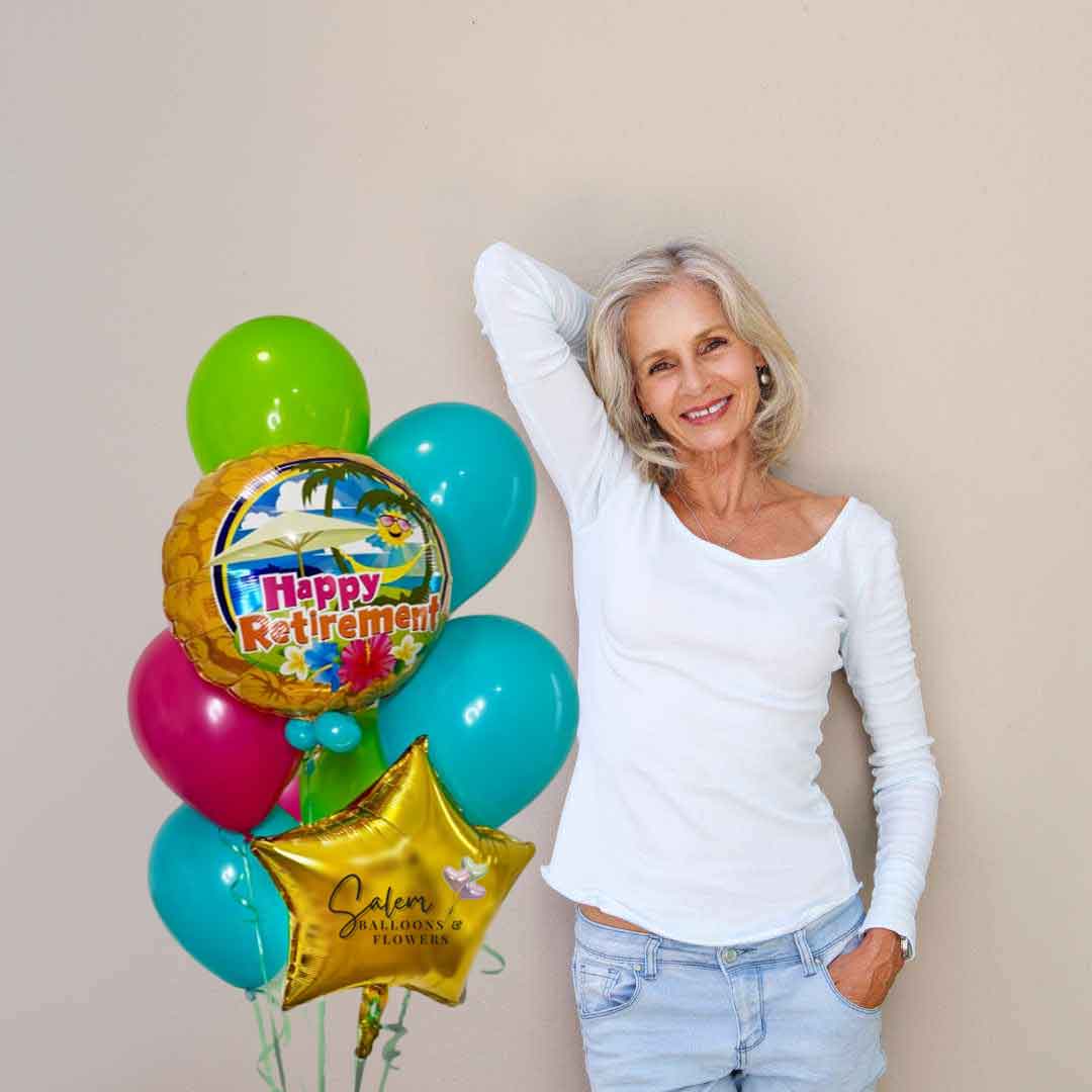 White hair lady standing beside a Hawaii-themed "Happy Retirement" Balloon Bouquet in colorful colors.. Salem -Keizer Oregon balloon delivery