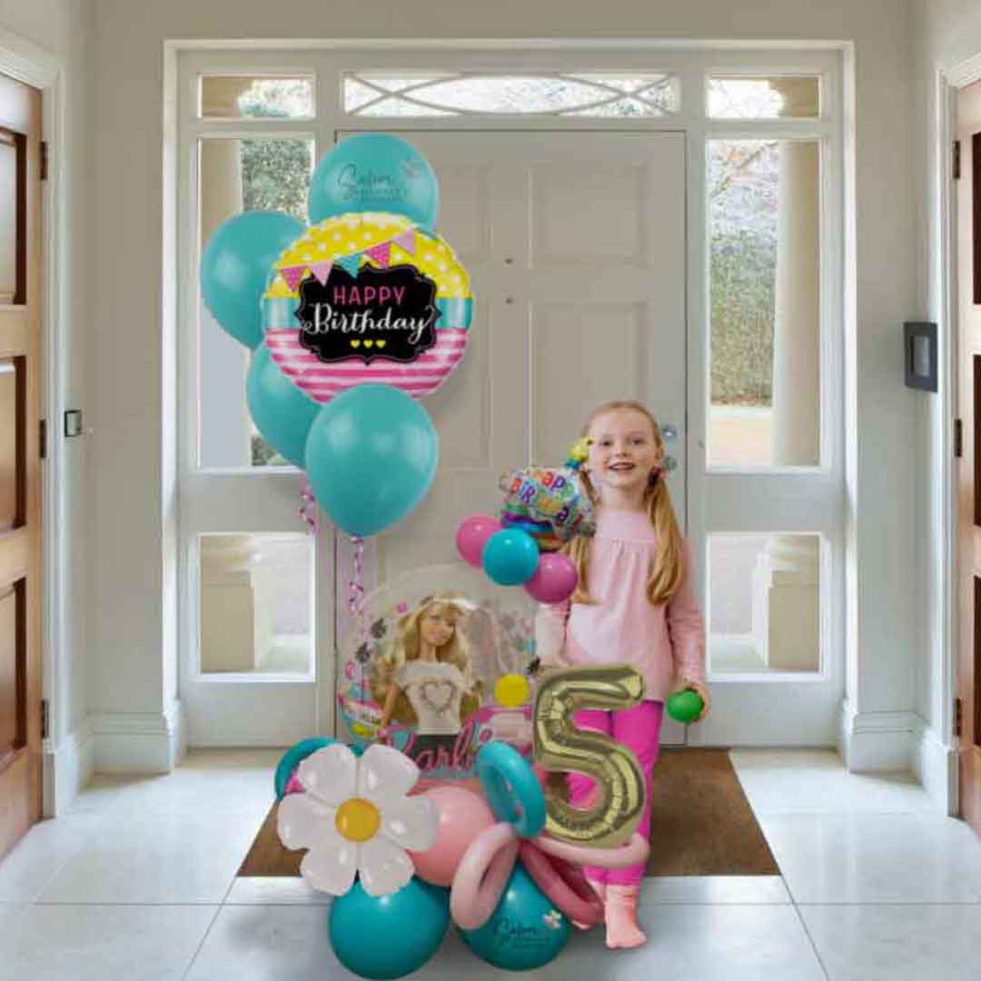 A little girl standing next to a 6 ft tall Barbie themed balloon bouquet in pinks and turquoise colors with a big barbie balloon. Oregon balloon delivery. Salem, Dallas, independence, Corvallis, Lake Oswego, Portland, McMinnville, Beaverton, Amity, Sublimity, and other nearby cities. 