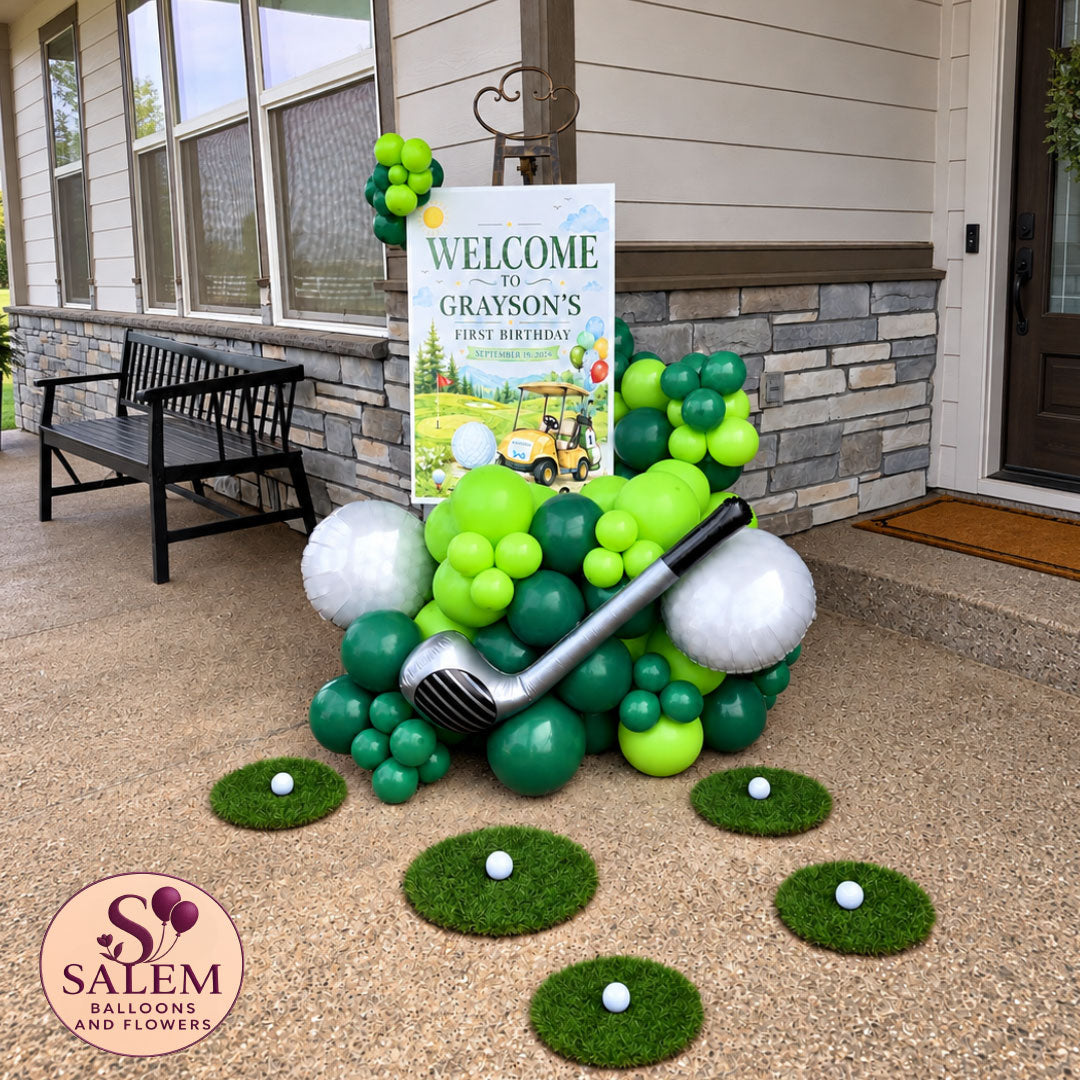 Hole in one. Golf themed balloon garland on an easel with round grass patches a golf club, and golf ball balloons decorating the entrance of a house  with a Salem Balloons and Flowers logo.