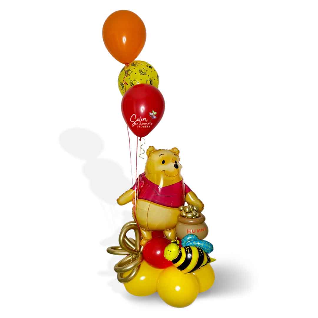 a Winnie the Pooh themed balloon bouquet with a large Winnie mylar balloon holding a honey pot filled with honey and bees. Oregon Balloon Delivery.