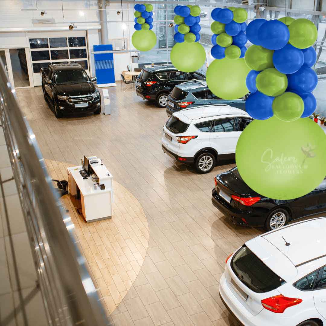Car dealership decorated with Inverted halve balloon columns in green and blue. Ceiling decoration. Salem Oregon balloon decor.