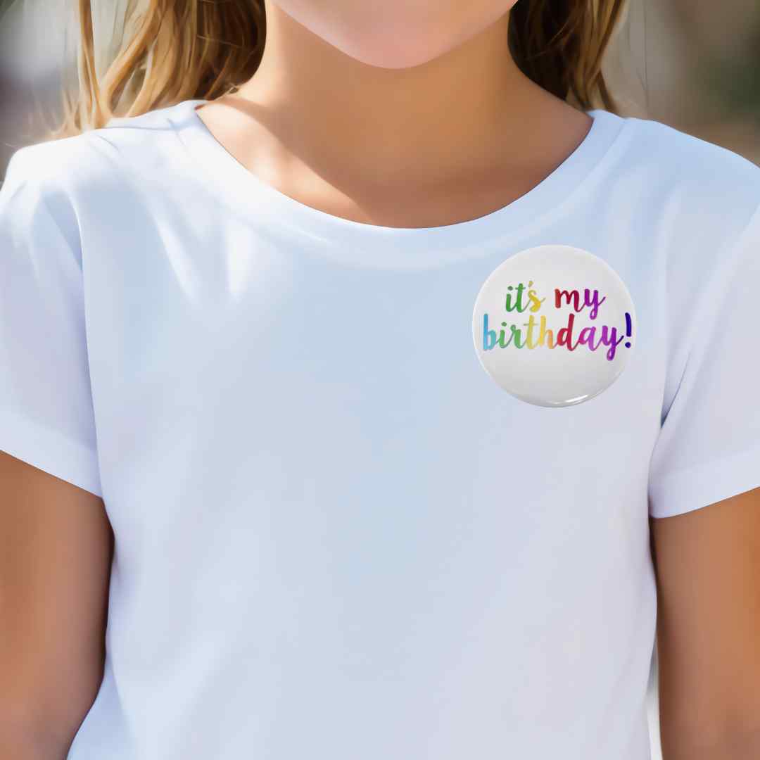 Girl wearing a white t-shirt with a White button pin with a colorful "It's my birthday" message. Salem Oregon balloon delivery