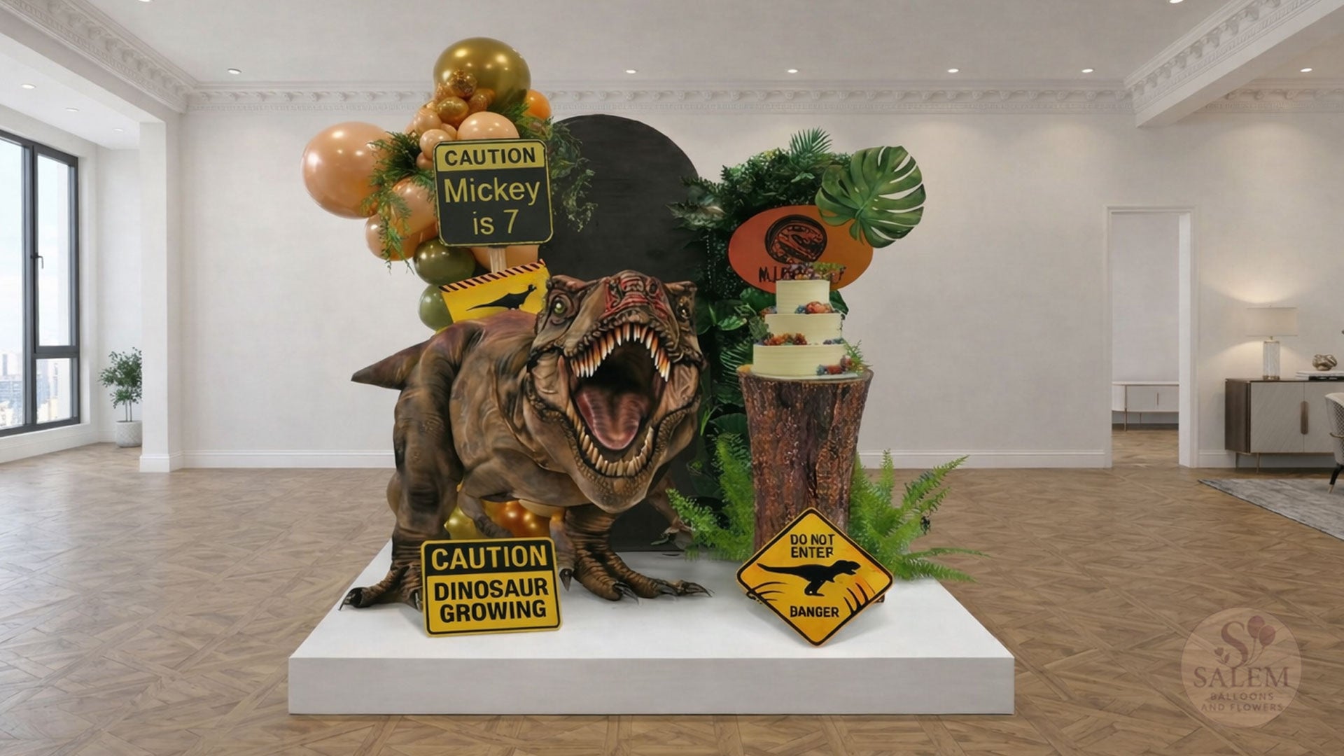 Dinosaur-Jurassic Park themed birthday balloon decoration, with a cake stand, greenery, balloon garlands, 2 panels, gian t-rex cutout, and signs in a decorated room. Balloon decor Oregon.