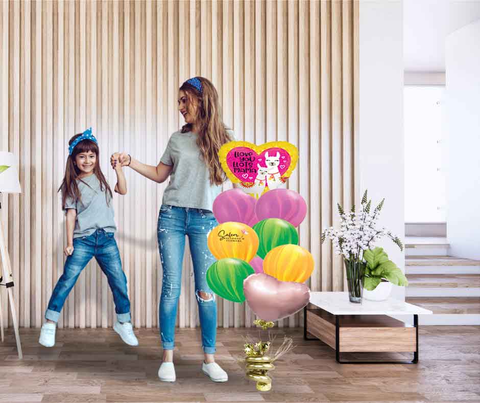 Mom and daughter standing next to a Mother's Day balloon bouquet, featuring a heart shaped mylar balloon with a cute mama lama and its baby with a 