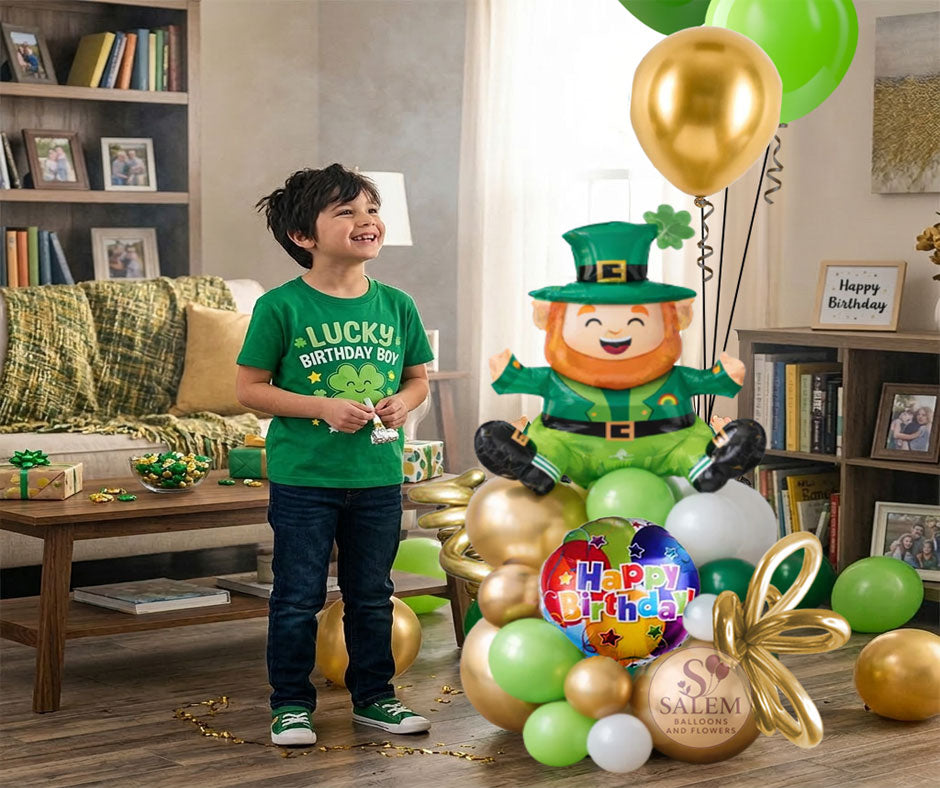 Birthday boy in a green shirt with a Lucky Birthday boy t-shirt, with balloons on the floor, and a Birthday  leprechaun themed  balloon arrangement in a living room.Birthday balloon Delivery Oregon.