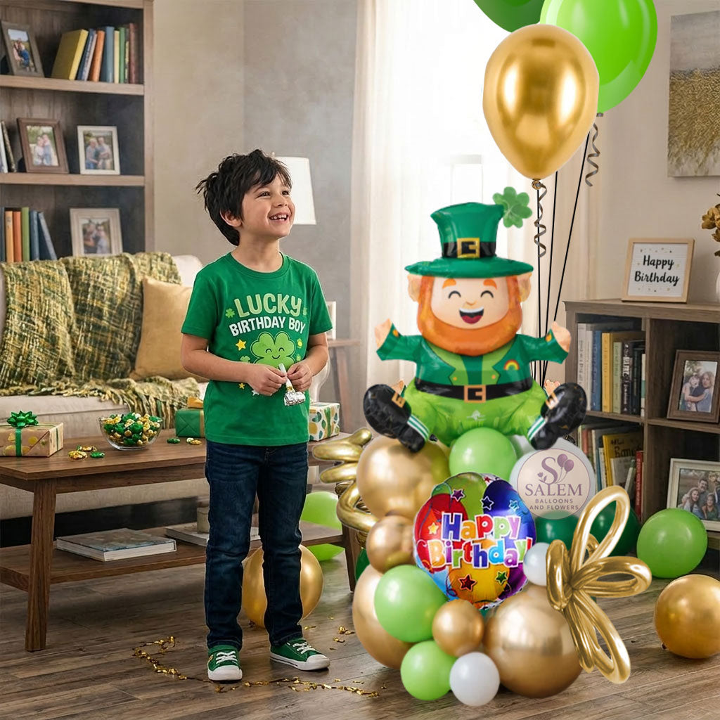 Birthday boy in a green shirt with a Lucky Birthday boy t-shirt, with balloons on the floor, and a Birthday  leprechaun themed  balloon arrangement in a living room.Birthday balloon Delivery Oregon.