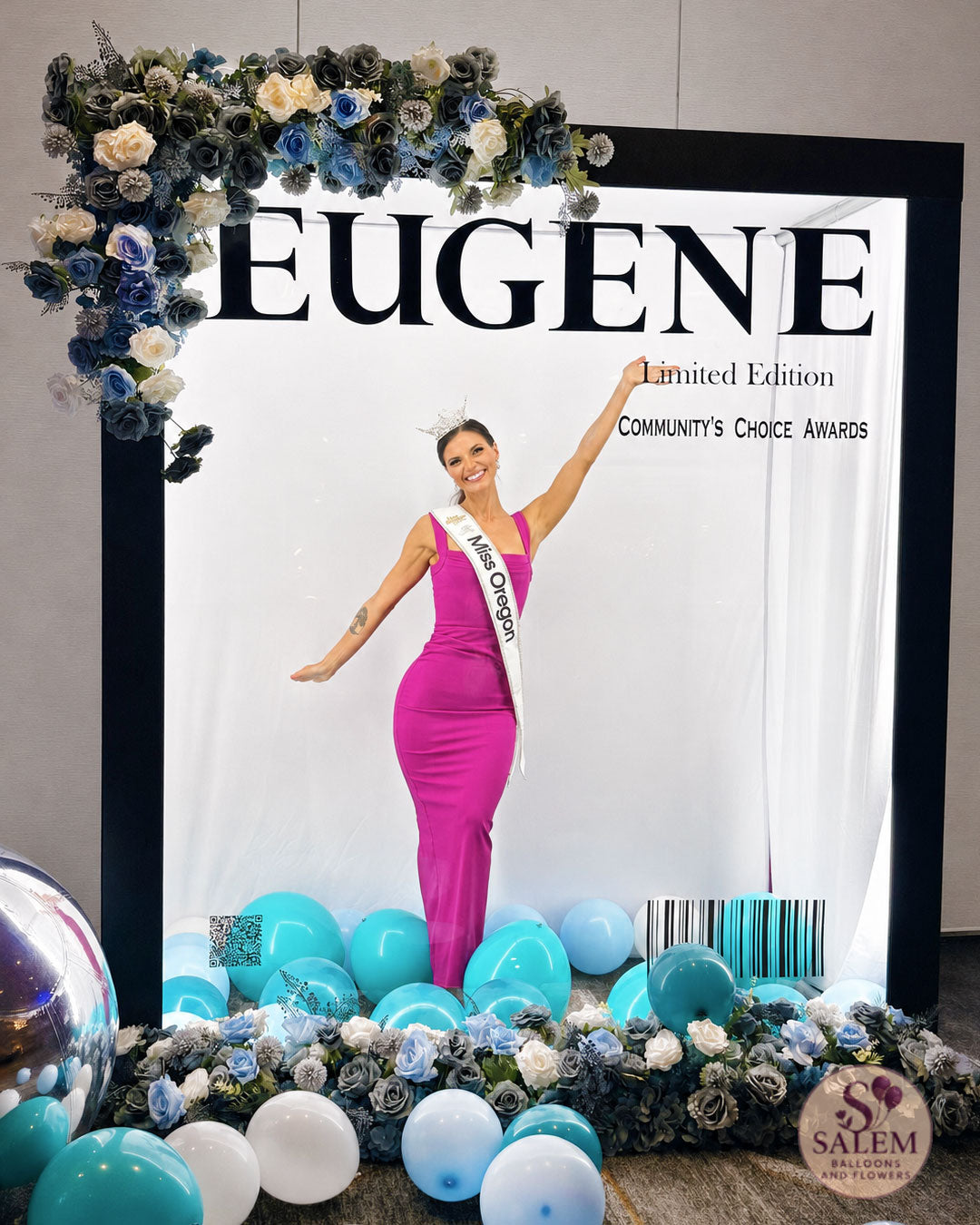 Magazine photo booth decorated with flowers with a banners spelling: Eugene, Community's choice awards at The Graduate Hotel, Limited Edition and Miss Oregon posing inside for pictures. By Salem Balloons and Flowers. 